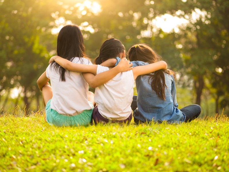 Children sitting with arms around each other