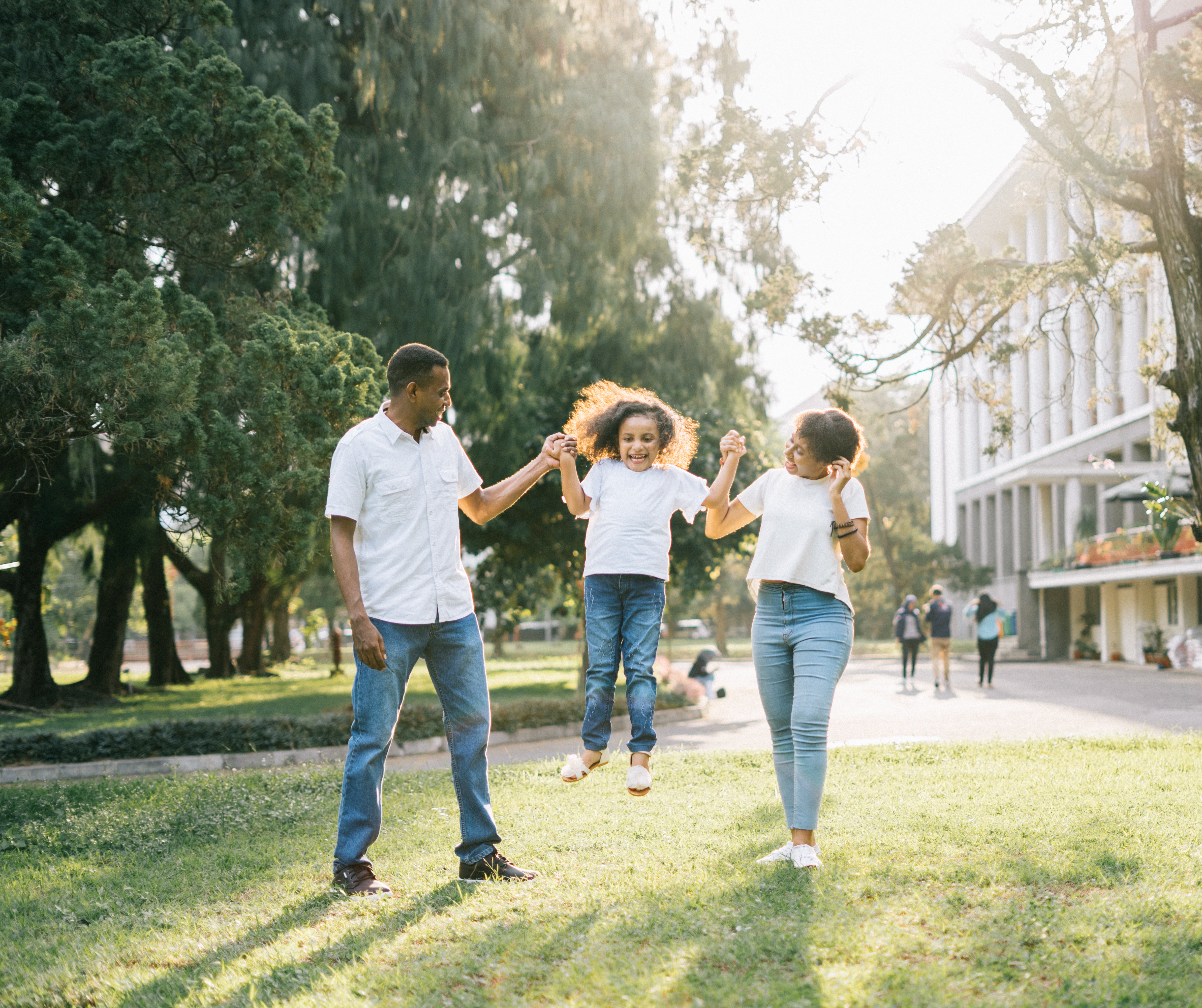 Parents holding hands and swinging child