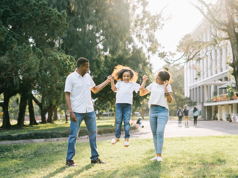 Parents holding hands and swinging child