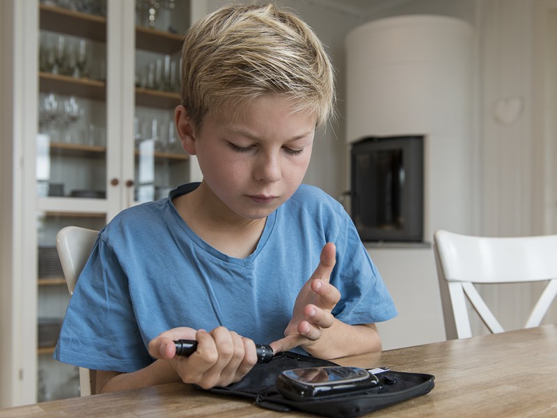 Young boy testing his blood sugar