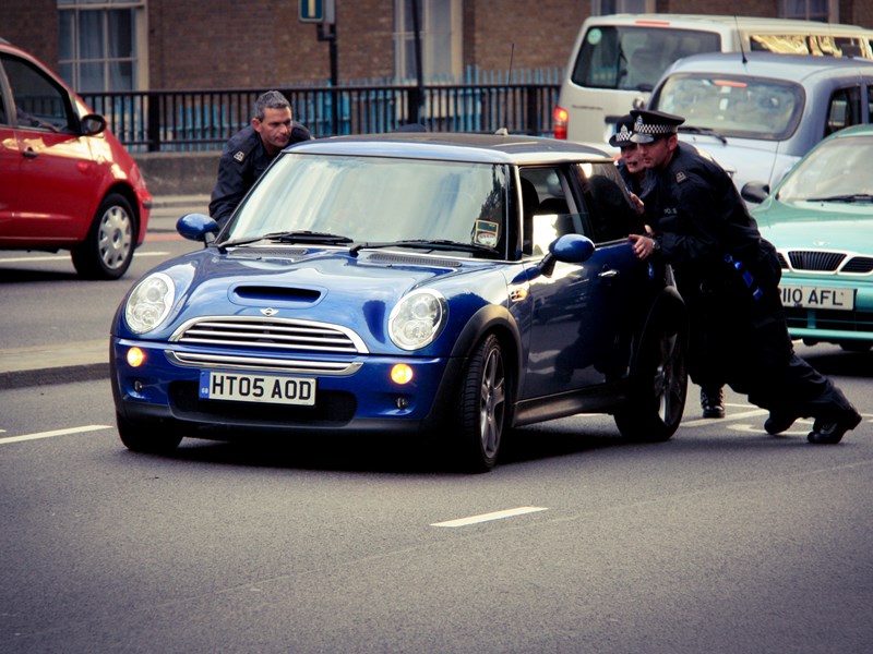 People helping to push a car that has broken down