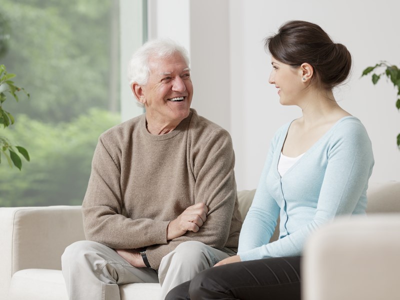 Man speaking to woman on couch