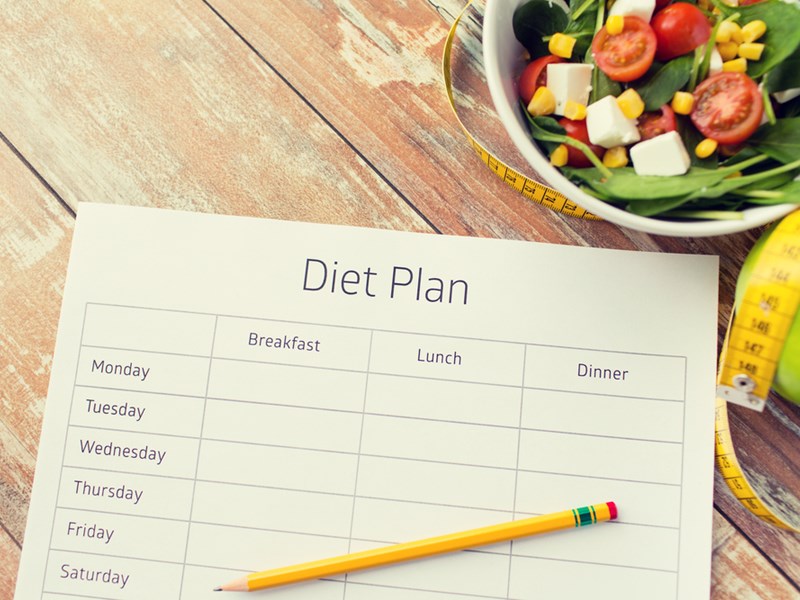 Diet plan with pencil, salad and tape measure