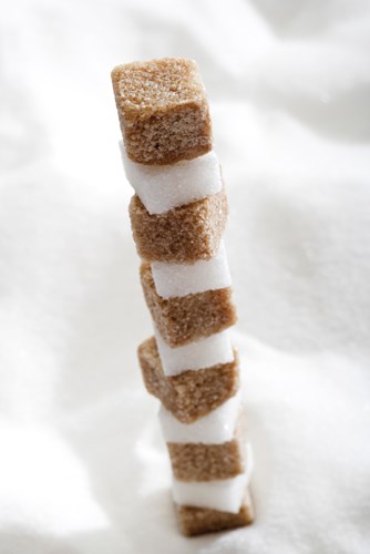 Brown and white sugar, sugar cubes stacked on a pile of sugar