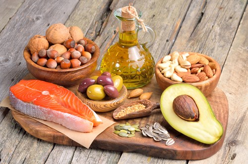 Selection of healthy fat sources on wooden background